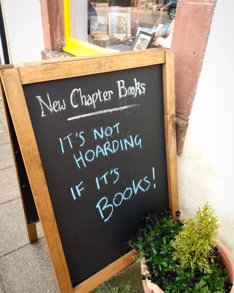 A sign outside New Chapter Books in Wigtown: 'It's not hoarding if it's books!'.